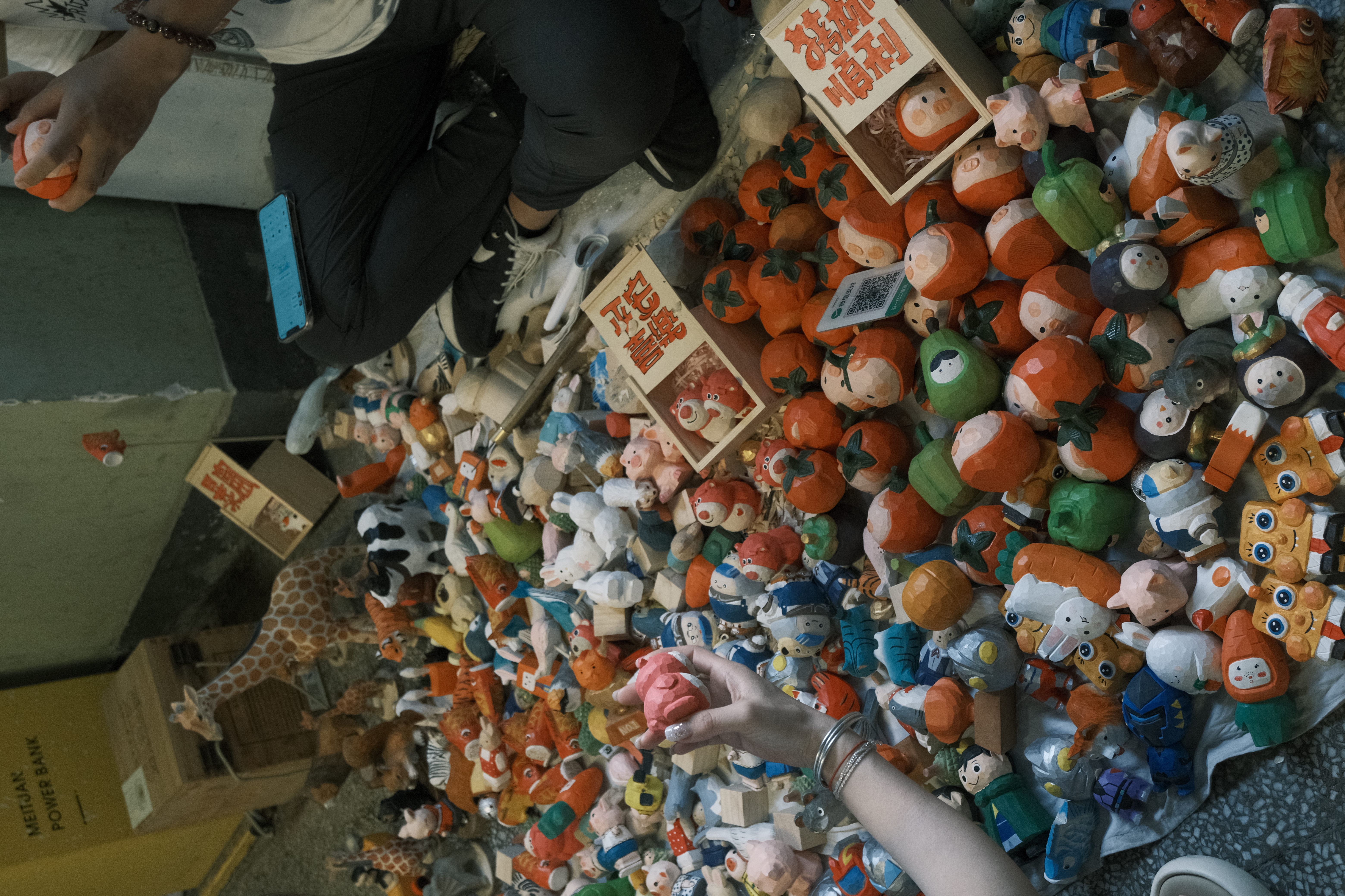 A dense collection of colourful figurines at a street stall