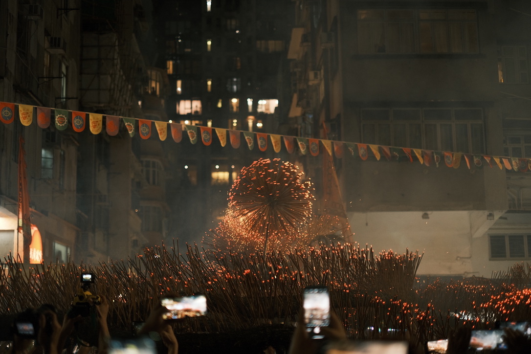 A glowing fire dragon moving through a crowded night street