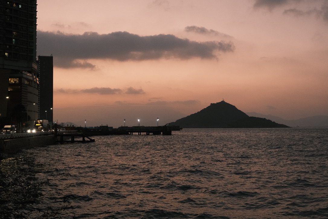 A quiet island silhouette across the water at dusk
